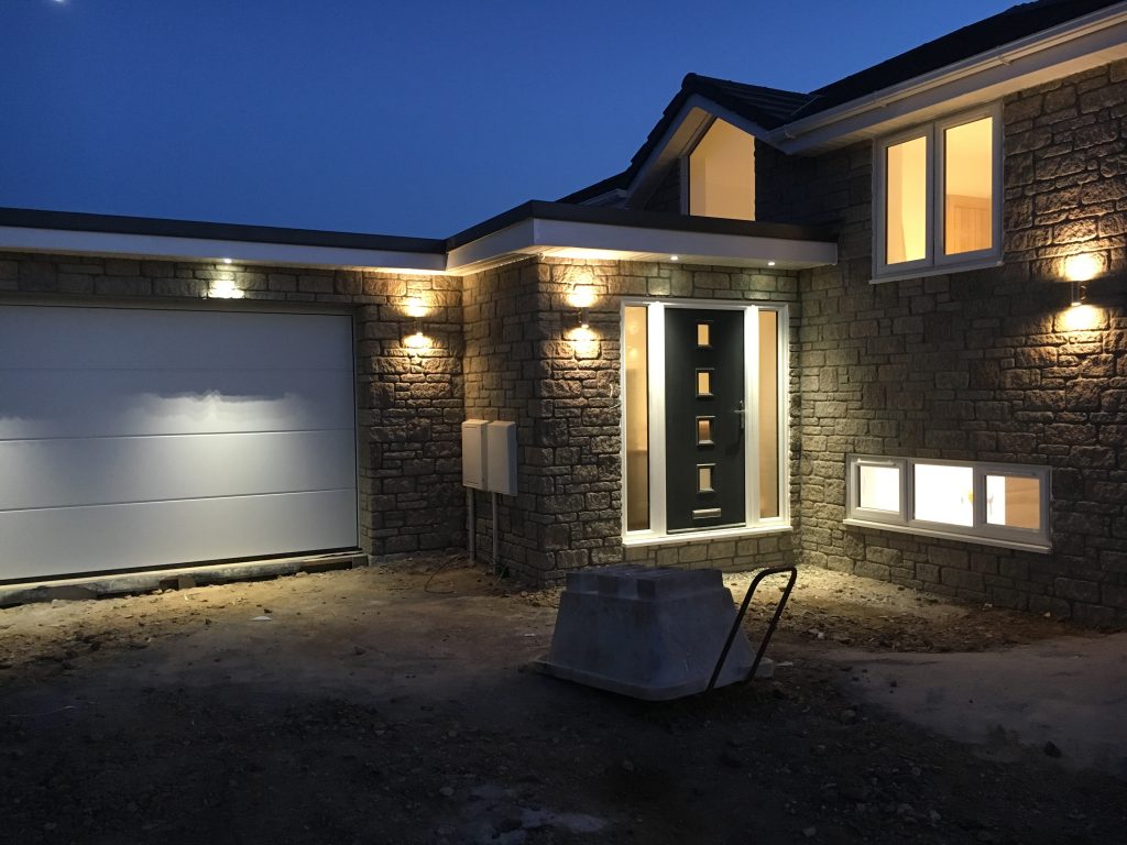 Exterior of a Smart Home in the final stages of contruction with outside lights on.